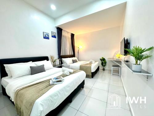 a hotel room with two beds and a couch at Ipoh Lahat Mines Private Pool Lake Villa by IWH Suites in Lahat