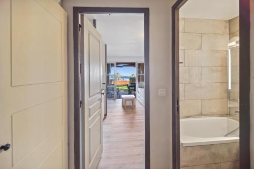 - une porte menant à une salle de bains pourvue d'une baignoire dans l'établissement Cap Estérel Magnifique vue mer avec parking et piscine, à Saint-Raphaël