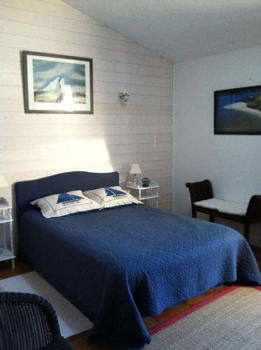 une chambre avec un lit avec une couverture bleue dans l'établissement Grande maison ancienne rénovée, à Saint-Pierre-dʼOléron