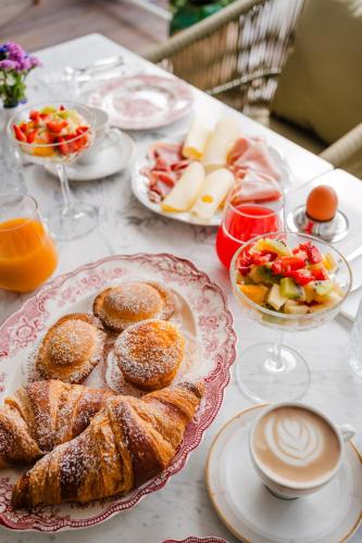 un tavolo ricoperto di piatti di prodotti da forno e ciotole di frutta di Corte Patitari - by Patitari Suites a Gallipoli