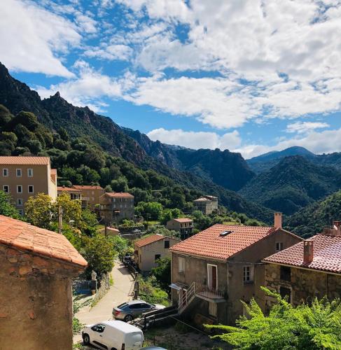 - une vue sur une ville avec des montagnes en arrière-plan dans l'établissement Peaceful haven in Corsica, à Guaita