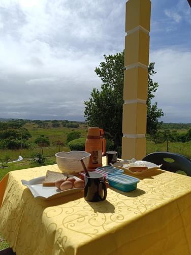 a table with a yellow table cloth with food on it at Machalele's House - Casa T2 acolhedora para casais e famílias na Ilha de Inhaca in Portinho da Inhaca