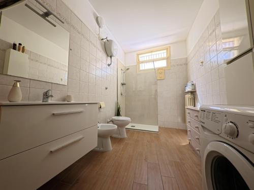a bathroom with a toilet and a sink and a washing machine at Palazzo Framarino dei Malatesta - Noble Floor - XIV Century in Giovinazzo