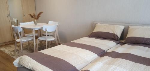two beds in a room with a table and chairs at Guboja in Nida