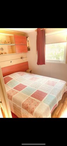 une chambre avec un lit avec une couette dessus dans l'établissement Camping Montana Parc 5 étoiles, à Puget-sur Argens