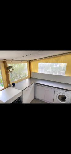 Elle comprend une petite cuisine avec des placards blancs et une fenêtre. dans l'établissement Camping Montana Parc 5 étoiles, à Puget-sur Argens