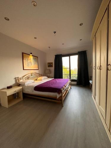 a bedroom with a large bed and a window at Villa Rose in Sheikh Zayed