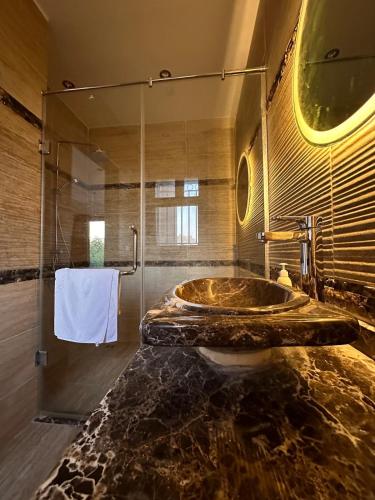 a bathroom with a marble sink and a shower at Villa Rose in Sheikh Zayed