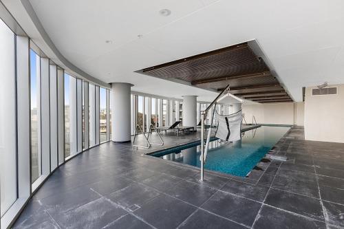an indoor swimming pool in a building with windows at Gorgeous High-Rise Unit with Sky Bar Pool and Gym in Melbourne