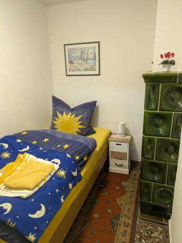 a bedroom with a bed with a blue comforter at Ferienhaus Am Freibad in Bad Berka