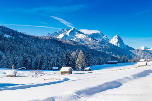 a snow covered field with mountains in the background at Ferienwohnung Ferienglück in Krün
