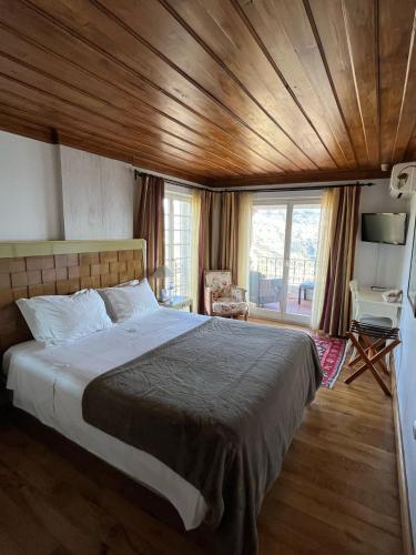 a bedroom with a large bed with a wooden ceiling at Casa De Canilhas in Mesão Frio