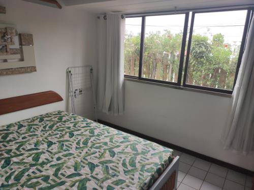 een slaapkamer met een bed en een raam bij Guarajuba Summer Flat in Guarajuba