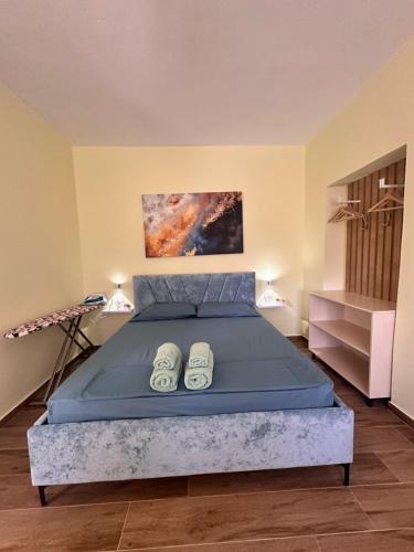 ein Schlafzimmer mit einem Bett mit blauer Bettdecke in der Unterkunft Vlora Vibe in Vlorë