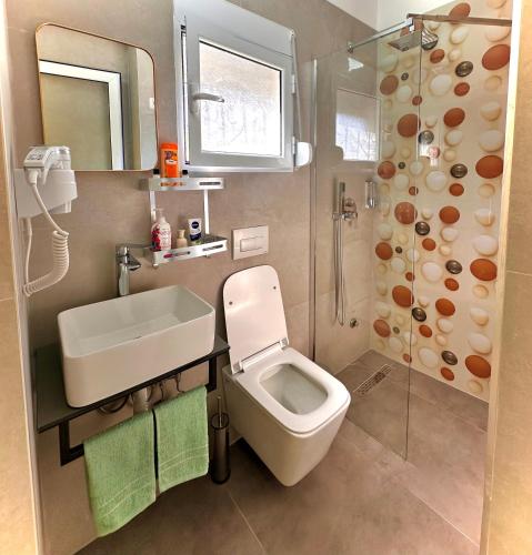 ein Badezimmer mit Toilette, Waschbecken und Dusche in der Unterkunft Vlora Vibe in Vlorë