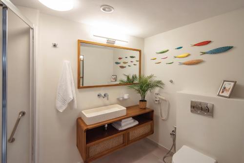 un baño con lavabo y espejo en Nasos Aegina Apartment, en Aegina Town