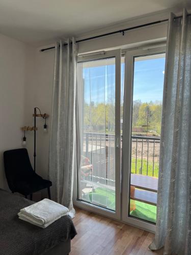 a bedroom with a large sliding glass door with a balcony at Cosy Rooms in Kraków