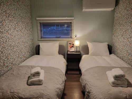 two beds in a room with towels on them at Quiet and spacious holiday home in Voorthuizen