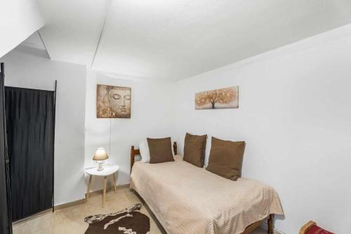 a white bedroom with a bed and a table at Sunshine House in Episkopianá