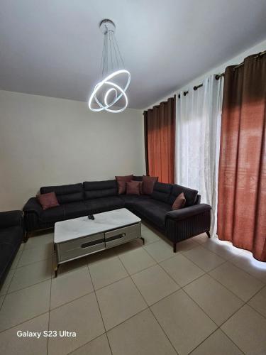 a living room with a couch and a table at E13 Samarah Resort Apartment in Sowayma
