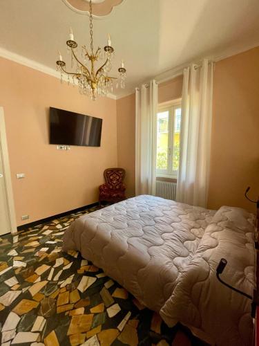 a bedroom with a large bed and a chandelier at 051 - Villa Genny Appartamento Agrumi in Sestri Levante