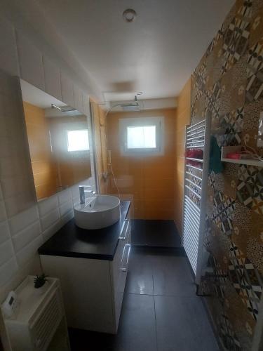 une salle de bain avec un lavabo et un miroir dans l'établissement Chambre d'hôte, à Bon-Encontre