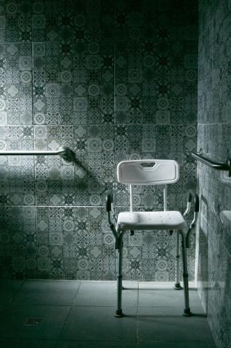 a white chair in a bathroom with a wall at OJO AZUL RESORT in Valle de Guadalupe