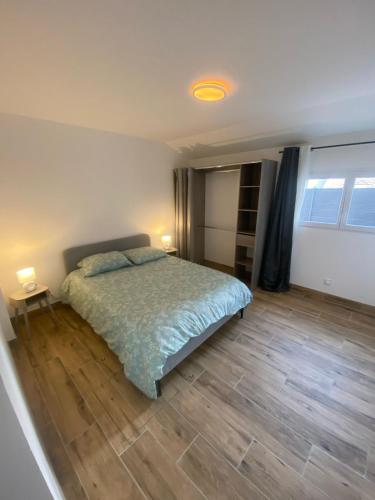 a bedroom with a bed and a wooden floor at maison ville in Chauny