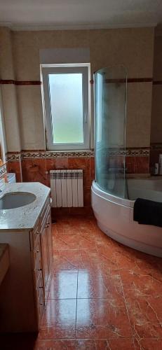a bathroom with a shower and a tub and a sink at Habitación doble con baño compartido in Cudón
