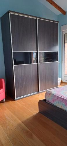 a bedroom with a large entertainment center with a bed at Habitación doble con baño compartido in Cudón