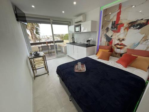 une chambre avec un grand lit avec un tableau au mur dans l'établissement Studio 2 couchage Cap d'Agde Naturisme CN0404-648, au Cap d'Agde