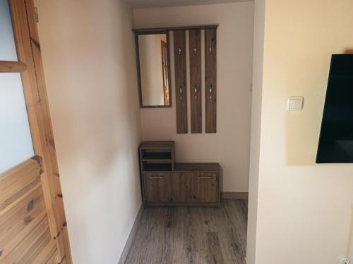 a hallway with a mirror and a dresser in a room at Dżem's Apartaments in Lidzbark Warmiński
