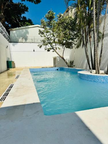 a swimming pool with blue water in front of a building at Casa Pura Vida in Puntarenas