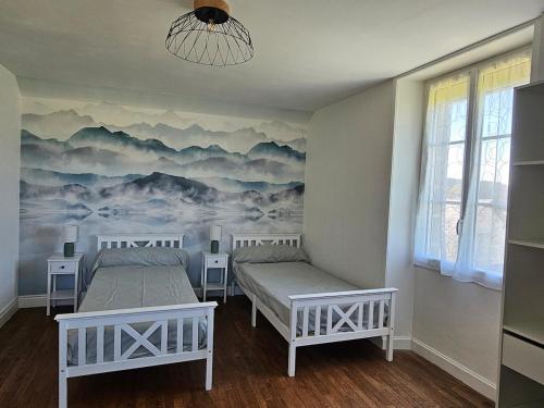 deux lits dans une chambre avec un tableau au mur dans l'établissement gîte au calme, à Les Coteaux Périgourdins
