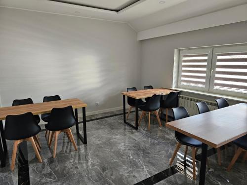 a room with tables and chairs and a window at Pensjonat-ek pod Jaworem in Hajnówka