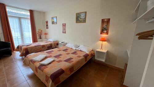 a bedroom with two beds and a lamp on a table at Le Signoret in Sault-de-Vaucluse