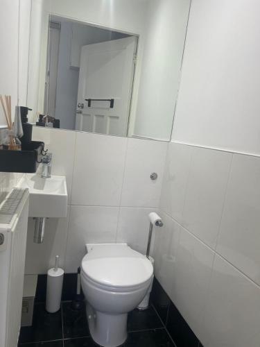 a white bathroom with a toilet and a sink at Large 3 bedrm apartment in heart of Theatre Land in London