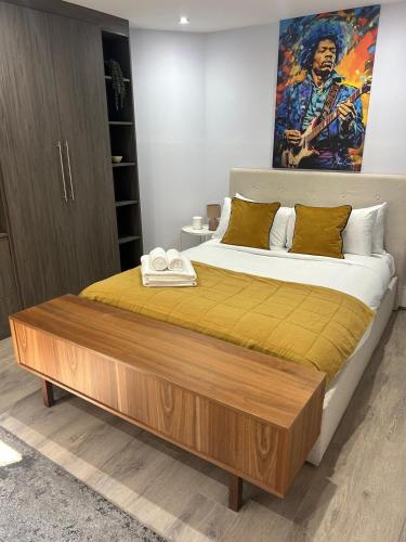 a bedroom with a large bed with a wooden headboard at Large 3 bedrm apartment in heart of Theatre Land in London