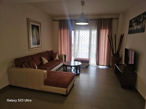 a living room with a couch and a table at E01 Samarah Resort One Bedroom apartment in Sowayma