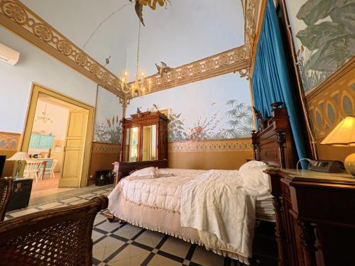 a bedroom with a bed and a painting on the wall at Palazzo Framarino dei Malatesta - Noble Floor - XIV Century in Giovinazzo