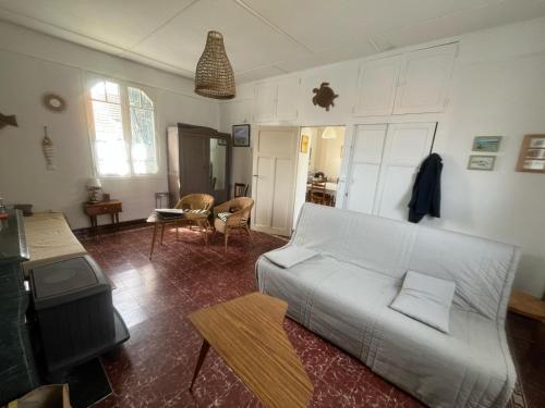 a living room with a white couch and a table at Maison avec jardin à 150 m de la plage in La Plaine-sur-Mer