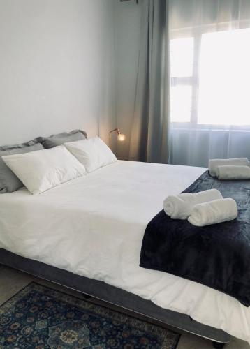 a bedroom with a bed with two towels on it at Self Catering Private Suite in Walvis Bay