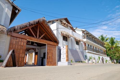 a building on a street with palm trees at Hôtel Baobab Café in Morondava