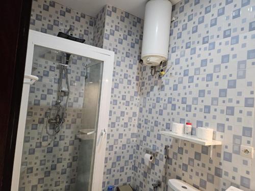 a bathroom with blue and gray tiles on the wall at Keur Aïda Immeuble de standing in Dakar