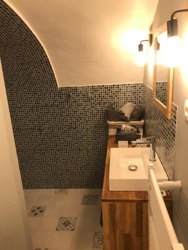 une salle de bain avec un lavabo et un miroir dans l'établissement Charmant studio, maison en pierre, terrace and garden, à Veyras