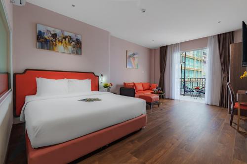 a bedroom with a large bed and a living room at Salute Saigon Hotel and Spa in Ho Chi Minh City