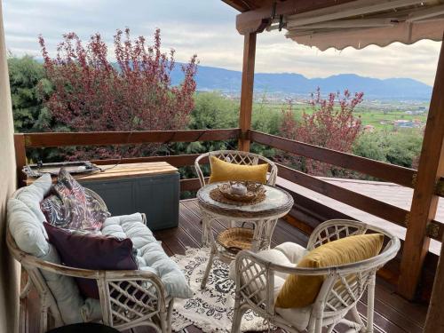 a porch with chairs and a table with a view at Romantic mountain cabin 10km to Skopje downtown in Skopje