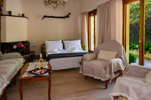 a bedroom with a bed and a couch and a table at Fotini's House Tsagarada Pelion in Tsagarada