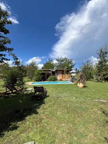 a yard with two picnic tables and a swimming pool at Gentil Morada in Villa Yacanto