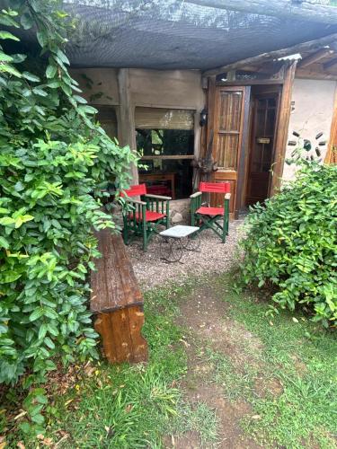 a patio with a bench and a table and chairs at Gentil Morada in Villa Yacanto